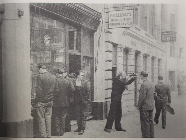 Vintage black and white still of shop owner